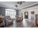 Spacious living room featuring a ceiling fan, shutters, wood floors, and an open doorway at 820 Nob Ridge Dr, Marietta, GA 30064