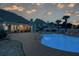 Backyard at dusk features a sparkling pool, patio with seating, and lush landscaping at 820 Nob Ridge Dr, Marietta, GA 30064