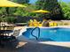 Inviting pool with sun loungers, yellow umbrellas, a table, and chairs in a well-maintained backyard at 820 Nob Ridge Dr, Marietta, GA 30064