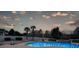 Backyard at dusk features pool with lounge chairs, palm trees, and landscape lighting at 820 Nob Ridge Dr, Marietta, GA 30064