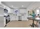 Modern kitchen featuring white cabinets, stainless steel appliances, and an adjacent dining area at 1576 Elixir Sw Ave, Atlanta, GA 30314