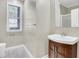 Bathroom features a sleek vanity with a sink, a large mirror, and a window with blinds at 2400 Cumberland Se Pkwy # 212, Atlanta, GA 30339