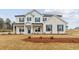 Charming two-story home with a painted brick facade, complemented by dark shutters and a well-manicured lawn at 801 Dobby Way (Lot 92), Mcdonough, GA 30252