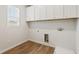 Laundry room with white cabinets and light wood-like flooring at 801 Dobby Way (Lot 92), Mcdonough, GA 30252