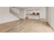 Hardwood floors and modern staircase leading to an open kitchen with sleek countertops and contemporary pendant lighting at 801 Dobby Way (Lot 92), Mcdonough, GA 30252