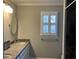 Well-lit bathroom with double vanity, granite counters, and window with stylish white shutters at 2860 Pine St, Duluth, GA 30096