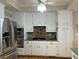 Well-lit kitchen featuring stainless steel appliances, white cabinetry, and a functional cooktop at 2860 Pine St, Duluth, GA 30096