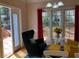 Comfortable living area with windows looking out to a deck, brightly colored chairs, and hardwood floors at 2860 Pine St, Duluth, GA 30096