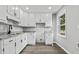 Bright kitchen boasts white cabinets, granite countertops, stainless steel faucet, and hardwood floors at 43 George Lemon Dr, Mcdonough, GA 30253