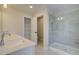 Bright bathroom featuring a double sink vanity, a glass-enclosed shower, and a linen closet for convenient storage at 4521 Twinberry Dr, Powder Springs, GA 30127