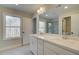 Elegant bathroom with dual sinks, a large mirror, and a window offering natural light and view to outdoors at 4521 Twinberry Dr, Powder Springs, GA 30127