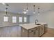 Bright kitchen with an island, stainless steel appliances, and an open floor plan leading to the living room at 4521 Twinberry Dr, Powder Springs, GA 30127