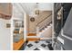 Inviting foyer features a black and white checkered tile floor and staircase with carpet runner at 19 Lullwater Ne Pl, Atlanta, GA 30307