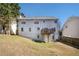 Back exterior of the house, with a large lawn and a small deck at 613 Lone Oak Dr, Lithonia, GA 30058