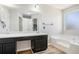 Primary bathroom has dual sinks, soaking tub, and frosted windows for privacy at 613 Lone Oak Dr, Lithonia, GA 30058