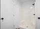 All white tiled shower with black fixtures and white door at 613 Lone Oak Dr, Lithonia, GA 30058