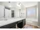 Primary bathroom has dual sinks, soaking tub, and frosted windows for privacy at 613 Lone Oak Dr, Lithonia, GA 30058