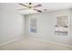Well-lit bedroom features neutral carpet, ceiling fan, and two large windows at 613 Lone Oak Dr, Lithonia, GA 30058