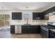 Functional kitchen with dark cabinets, stainless steel appliances, and a scenic view to the backyard at 613 Lone Oak Dr, Lithonia, GA 30058