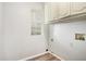 Laundry room with vinyl floor and window; cabinets mounted overhead at 613 Lone Oak Dr, Lithonia, GA 30058