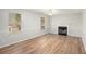 Inviting living room with modern flooring, two large windows and a cozy fireplace at 613 Lone Oak Dr, Lithonia, GA 30058