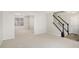 Bright living room features neutral carpet, white walls, staircase, and view to dining room at 613 Lone Oak Dr, Lithonia, GA 30058