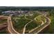 An aerial view of a community with manicured green spaces, walking paths, and modern buildings at 104 Stonehouse Dr, Cumming, GA 30040