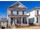 Charming two-story home with light blue siding, a covered front porch, and professionally landscaped yard at 104 Stonehouse Dr, Cumming, GA 30040