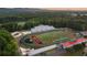 Aerial view of well-maintained high school football stadium and track surrounded by lush trees at 104 Stonehouse Dr, Cumming, GA 30040