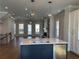 Open-concept kitchen featuring an island with a stainless steel sink, pendant lighting, and modern appliances at 104 Stonehouse Dr, Cumming, GA 30040