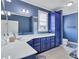 A blue bathroom features white countertops, a double vanity, a built-in cabinet, and tile flooring at 179 Worthington Way, Jonesboro, GA 30236