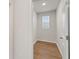 Hallway with hardwood floors, a window, and white trim provides a bright and welcoming space at 267 Arwen Drive (Lot 66), Mcdonough, GA 30252