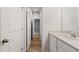 Hallway leading to bathroom with wood look floors, white cabinets and neutral walls at 267 Arwen Drive (Lot 66), Mcdonough, GA 30252