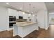 Contemporary kitchen with white cabinets, granite countertops, and stainless steel appliances, offering a sleek design at 267 Arwen Drive (Lot 66), Mcdonough, GA 30252