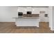 Modern kitchen with a center island, white cabinetry, and stainless steel appliances, perfect for culinary enthusiasts at 267 Arwen Drive (Lot 66), Mcdonough, GA 30252