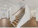 Elegant staircase with wooden handrails and iron balusters, adding a touch of sophistication to the home's interior at 267 Arwen Drive (Lot 66), Mcdonough, GA 30252