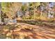 Backyard featuring mature trees, wooden retaining wall, and sunlight on the ground at 267 Windy Cir, Mcdonough, GA 30253