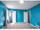 Carpeted bedroom featuring blue walls, natural light, and closet access at 3959 Emerald Springs Ct, Decatur, GA 30035