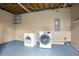 Functional laundry room features a washer, dryer, blue painted floors, and built in shelving at 3959 Emerald Springs Ct, Decatur, GA 30035