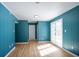 Spacious room featuring blue walls, wood floors, and glass patio doors at 3959 Emerald Springs Ct, Decatur, GA 30035