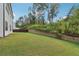 The expansive backyard features lush green grass and mature trees, providing a private outdoor space at 6235 Banyan Trl, Cumming, GA 30028