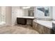 Bathroom showcases double sinks, soaking tub with tiled surround, and a tiled floor; and a doorway to the toilet at 6235 Banyan Trl, Cumming, GA 30028