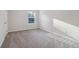 Bedroom with neutral walls, carpeted floors, a window for natural light, and an electrical outlet at 6235 Banyan Trl, Cumming, GA 30028