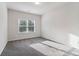Bright bedroom featuring soft carpet, large window, and neutral color palette at 6235 Banyan Trl, Cumming, GA 30028