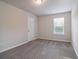 Neutral-toned bedroom with carpet flooring, window with blinds, white doors and trim, and electrical outlets at 6235 Banyan Trl, Cumming, GA 30028