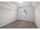 Walk-in closet boasts carpet flooring, ample storage, and a window providing natural light for viewing clothing at 6235 Banyan Trl, Cumming, GA 30028