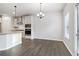 Bright dining area features hardwood floors and a modern chandelier next to the gourmet kitchen at 6235 Banyan Trl, Cumming, GA 30028