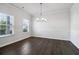 Bright dining room featuring hardwood floors, wainscoting, and modern chandelier at 6235 Banyan Trl, Cumming, GA 30028