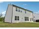 Back view of the home with light siding, showcasing a spacious backyard and ample natural light at 6235 Banyan Trl, Cumming, GA 30028
