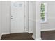 Bright foyer with hardwood floors, a white door, and views of the dining room at 6235 Banyan Trl, Cumming, GA 30028